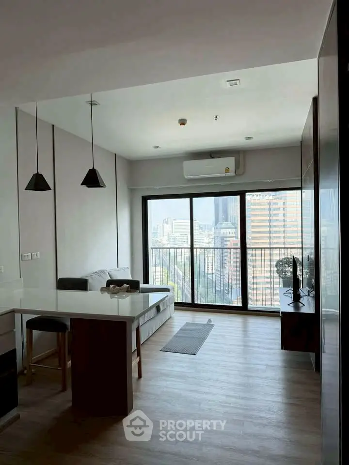 Modern living room with city view and stylish furniture in high-rise apartment.