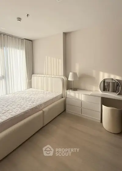 Elegant minimalist bedroom with natural light and modern furnishings.