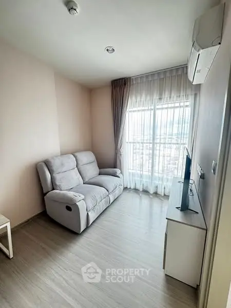 Cozy living room with modern sofa and TV, featuring a large window with city view.