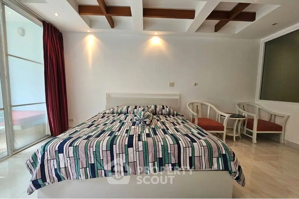 Spacious bedroom with modern decor and large windows for natural light.