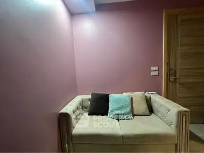 Cozy small living room with plush sofa and pastel walls