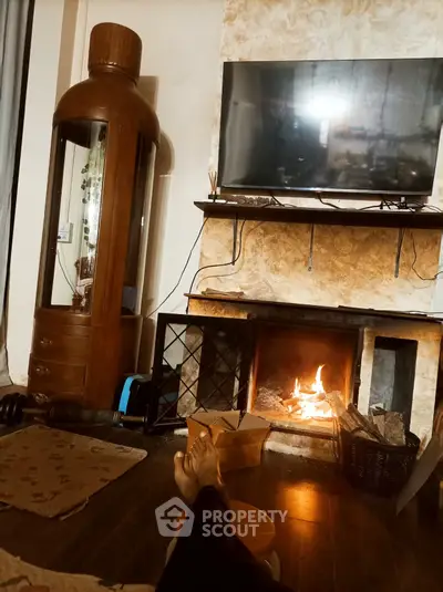 Cozy living room with fireplace and mounted TV, perfect for relaxation.