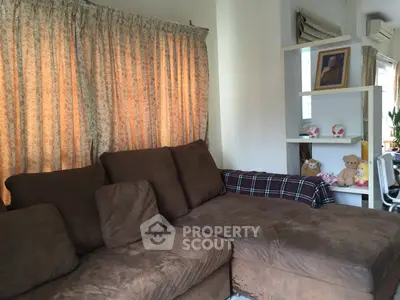 Cozy living room with plush brown sofa and decorative shelves, perfect for relaxation.
