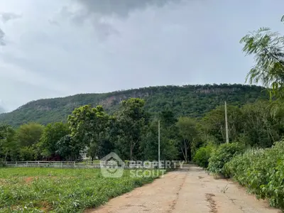 Scenic view of lush green landscape with mountain backdrop, ideal for serene living.