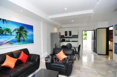 Spacious modern living room with leather sofas and open kitchen layout