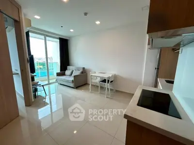 Modern living room with open kitchen and city view, featuring sleek furniture and bright natural light.