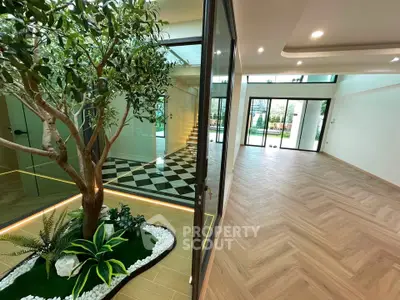 Luxurious modern interior with elegant flooring and indoor garden, showcasing spacious living area and large windows.