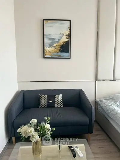Cozy living room with modern sofa, stylish decor, and elegant artwork, perfect for relaxation and comfort.