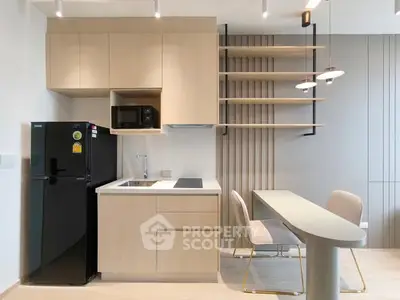 Modern kitchen with sleek cabinetry, compact dining area, and integrated appliances in a stylish apartment.