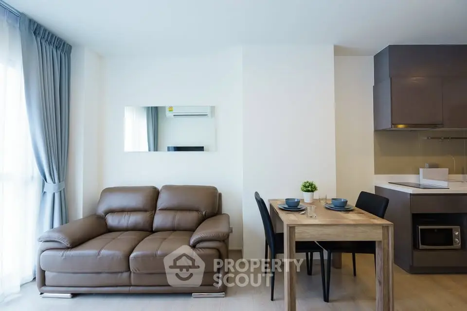 Modern living room with cozy leather sofa and dining area in open layout apartment.