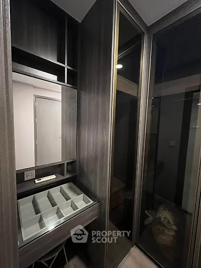 Modern walk-in closet with sleek dark wood finish and ample storage space.