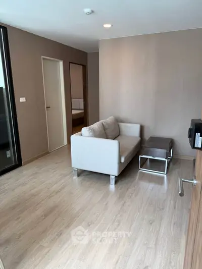 Modern living room with sleek wooden flooring and cozy sofa in a stylish apartment.
