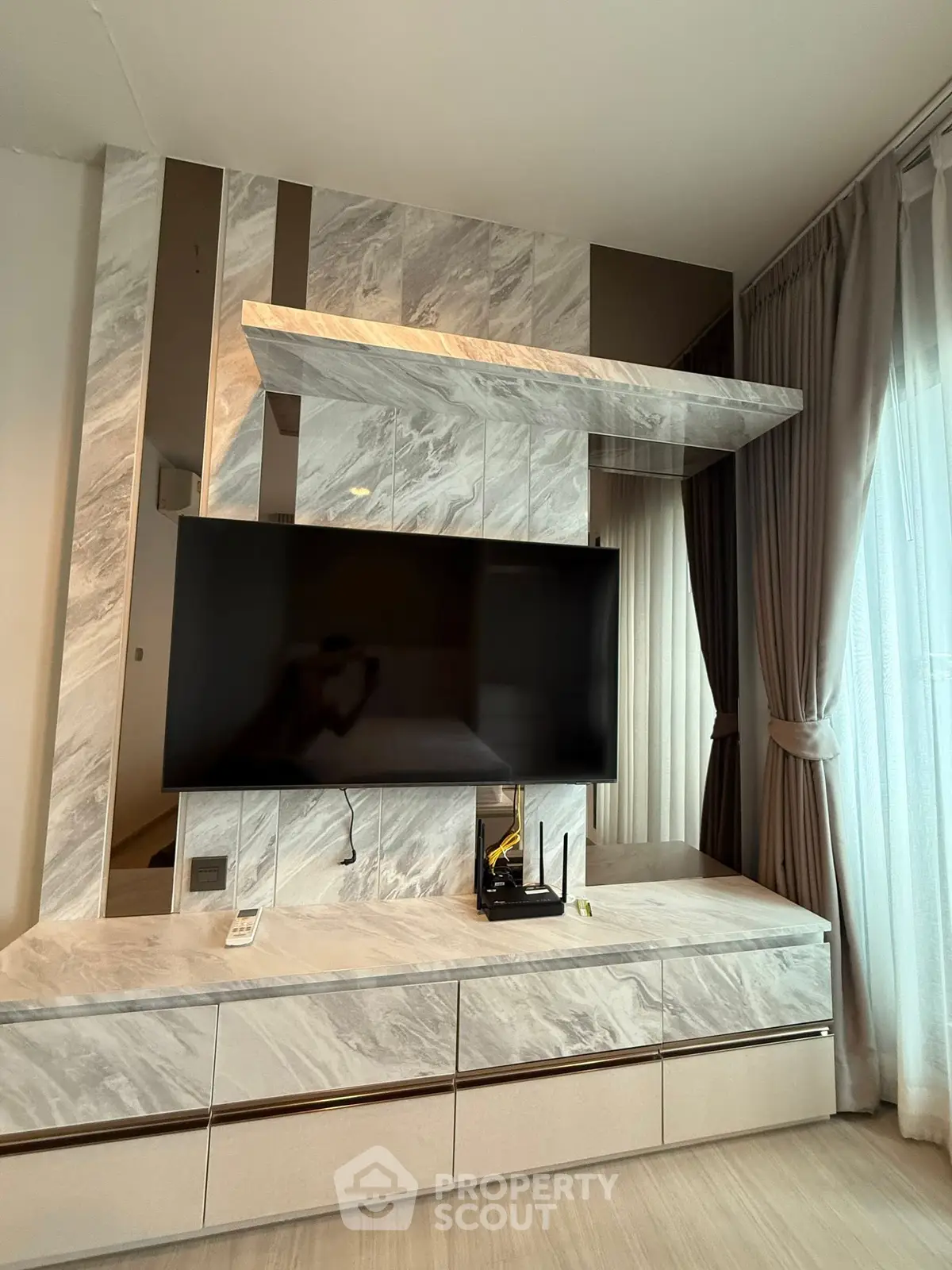 Modern living room with sleek marble TV wall and elegant curtains