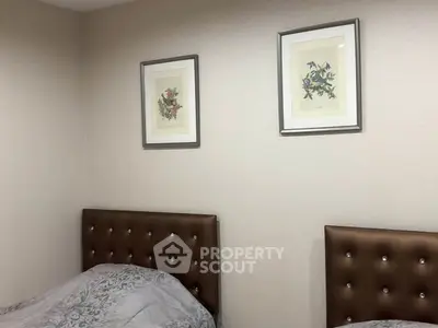 Cozy bedroom with twin beds and elegant framed artwork on the wall.