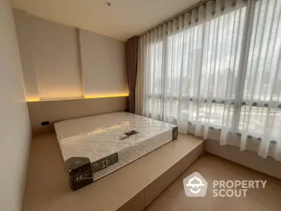 Modern bedroom with large windows and built-in platform bed in a high-rise apartment.