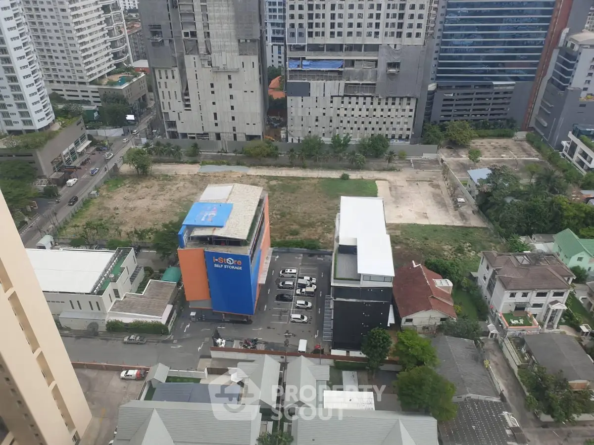 Aerial view of urban development site with surrounding buildings and parking area.