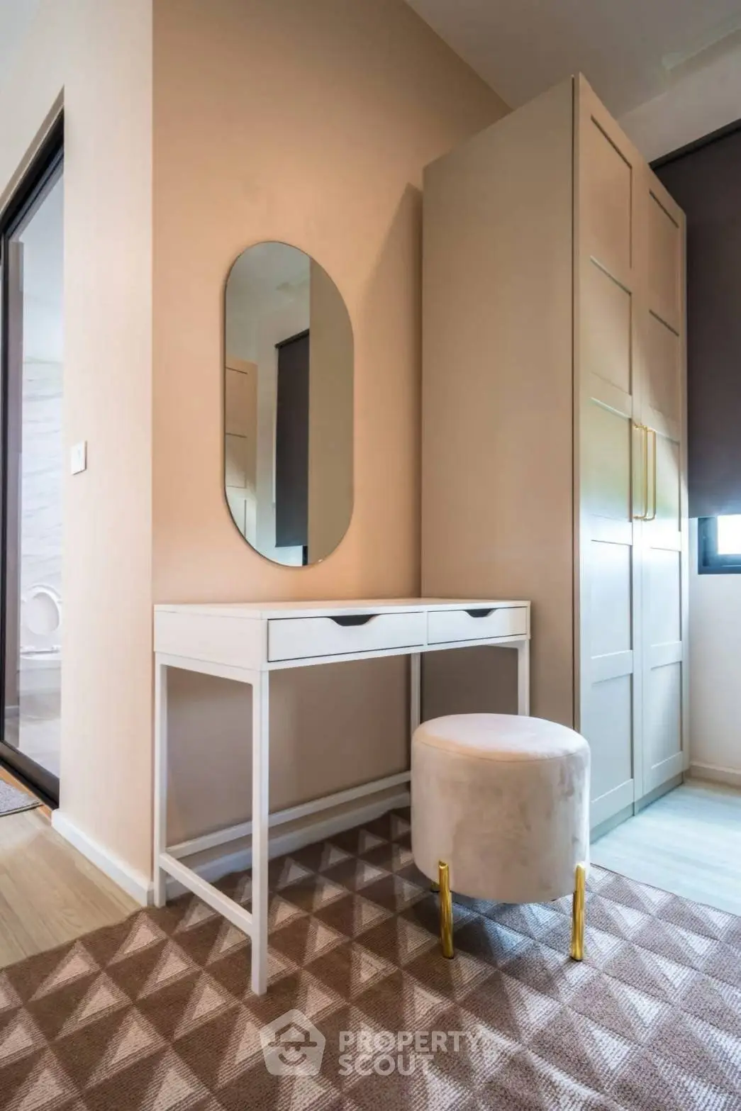 Stylish bedroom corner with modern vanity and plush stool in elegant apartment.
