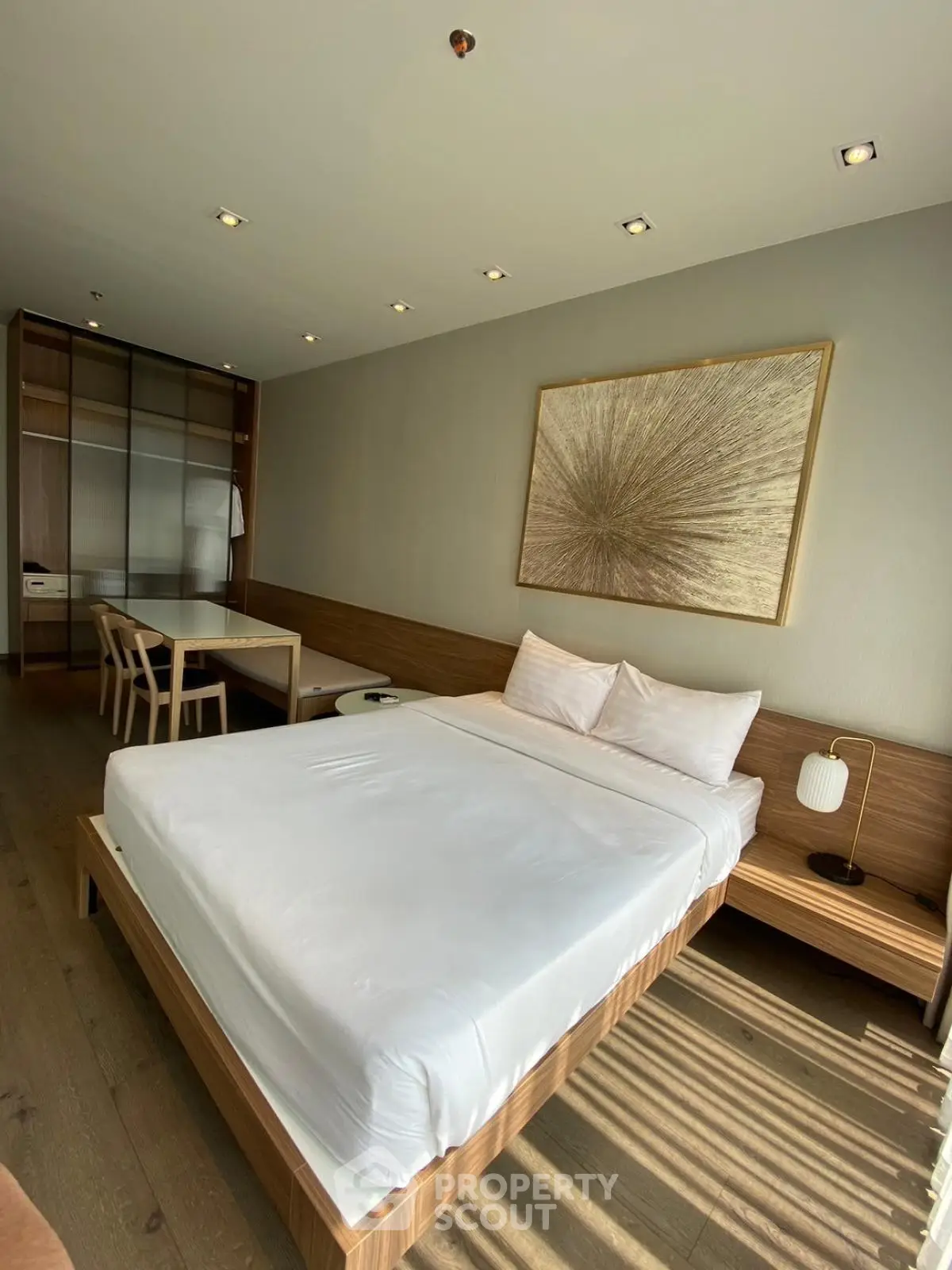Modern bedroom with stylish decor and ample natural light, featuring a cozy bed and elegant furnishings.