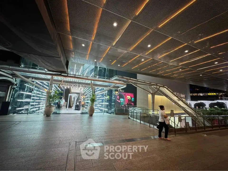 Modern commercial building entrance with sleek design and illuminated signage.