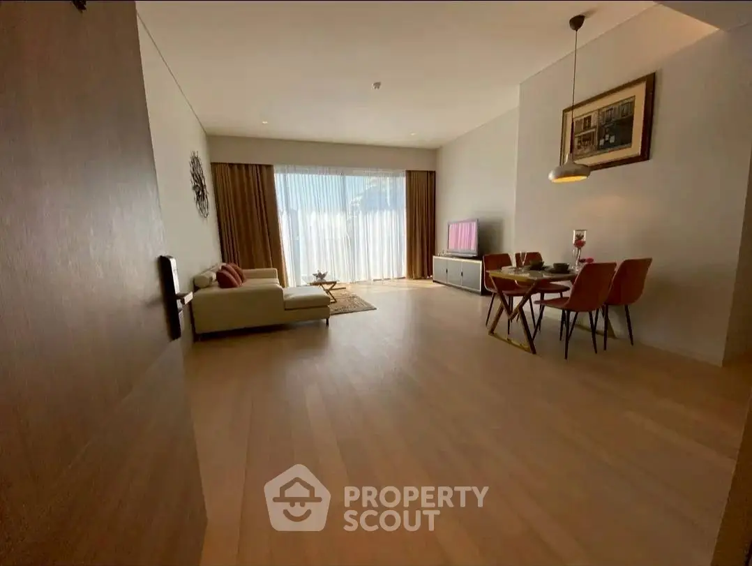 Spacious living room with elegant decor and dining area, featuring large windows and modern furnishings.