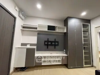 Modern living room with built-in storage and TV mount, showcasing sleek design and ample space.