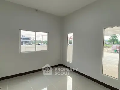 Bright empty room with large windows and glossy tiled floor, perfect for customization.