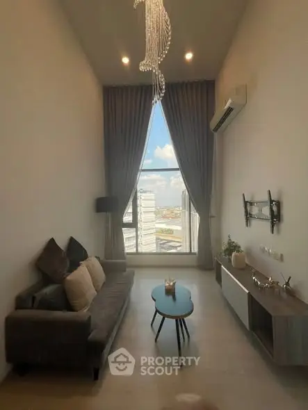 Modern living room with high ceiling and large window offering city view