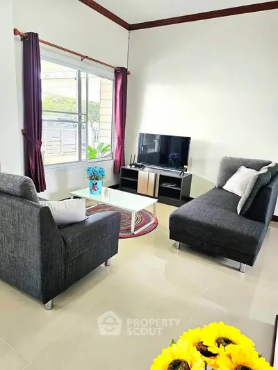 Charming living room with modern furniture and natural light, perfect for relaxation and entertainment.