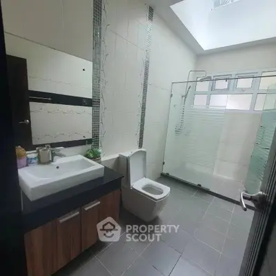 Modern bathroom with skylight and sleek fixtures in contemporary home