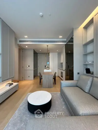Modern living room with open kitchen, sleek furniture, and elegant lighting in a stylish apartment.