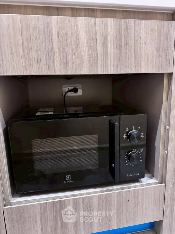 Modern kitchen with built-in microwave oven in sleek wooden cabinetry.