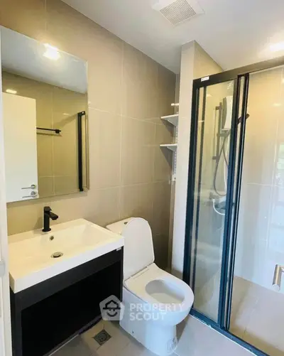 Modern bathroom with sleek shower and stylish vanity in contemporary apartment.