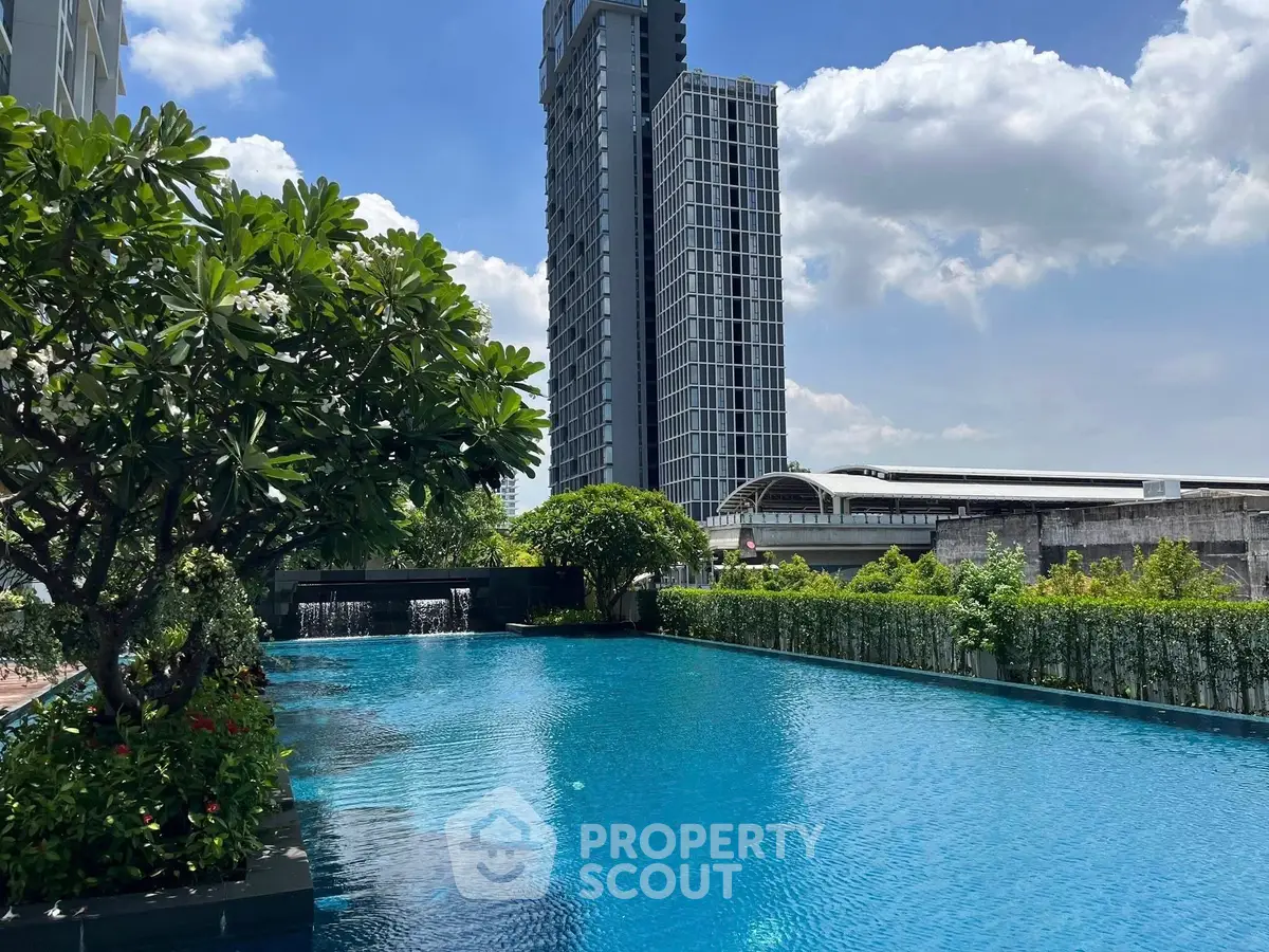 Luxurious high-rise building with stunning pool and lush greenery