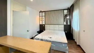 Spacious modern bedroom with elegant decor and large windows for natural light.