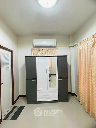 Spacious bedroom with modern wardrobe and air conditioning unit.