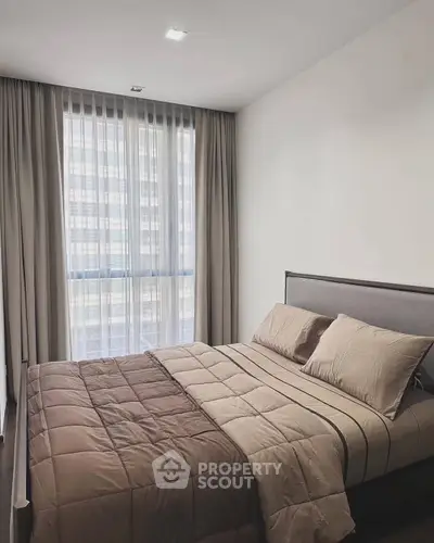 Modern bedroom with large window and elegant curtains in a stylish apartment.