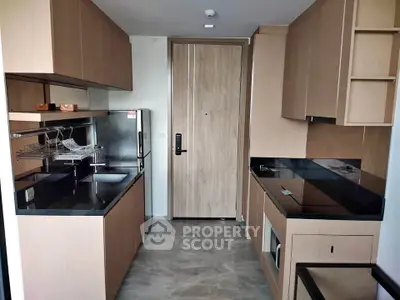 Modern kitchen with sleek cabinetry and black countertops in a stylish apartment.