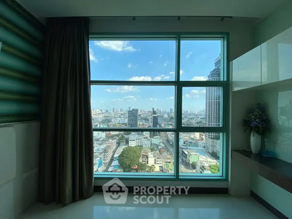 Stunning city view from modern high-rise apartment window with sleek interior design.