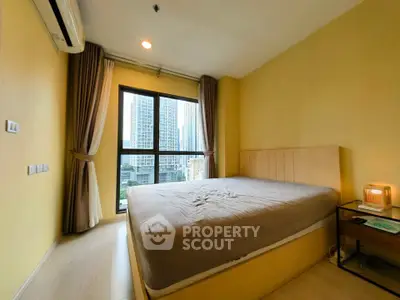 Cozy bedroom with large window offering city view in modern apartment