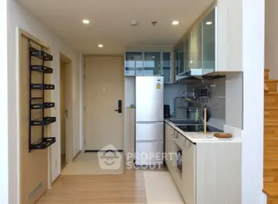Modern compact kitchen with sleek cabinetry and integrated appliances in a stylish apartment.