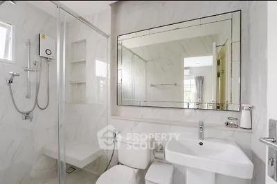 Modern bathroom with sleek fixtures and large mirror in a bright, elegant setting.