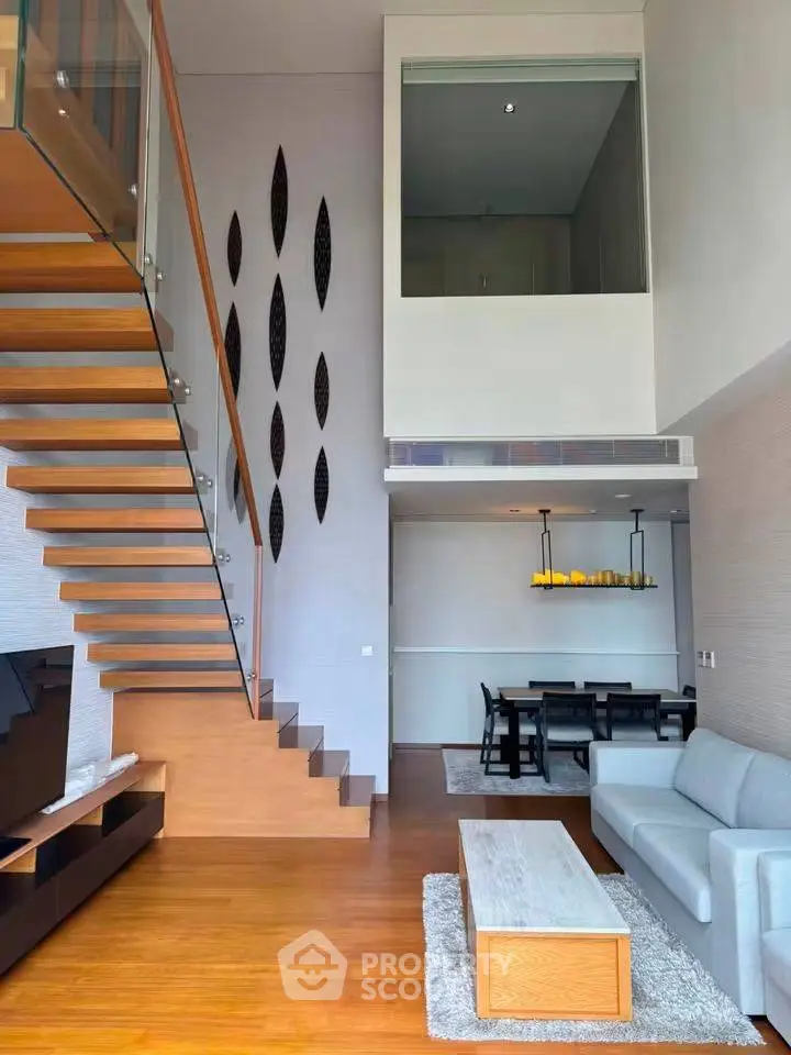 Modern duplex living room with stylish staircase and elegant dining area