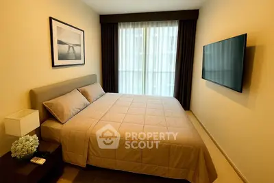 Cozy modern bedroom with elegant decor and wall-mounted TV, perfect for relaxation.