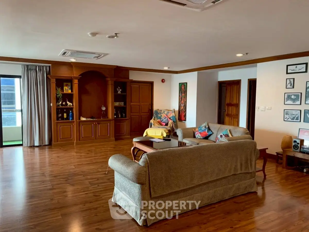 Spacious living room with elegant wooden flooring and cozy seating area.