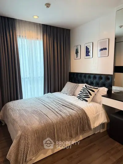 Modern bedroom with stylish decor and natural light, featuring a cozy bed and elegant curtains.