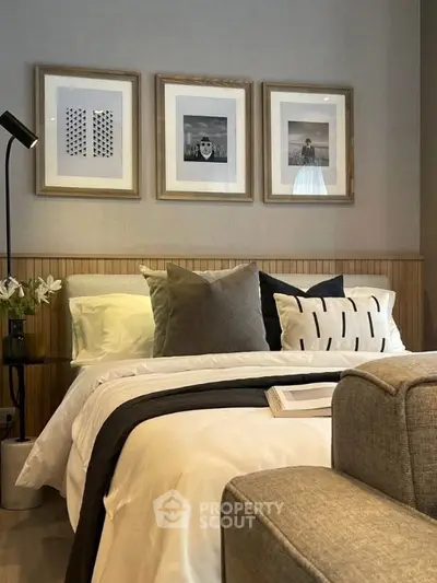 Stylish bedroom with modern decor and cozy ambiance, featuring elegant framed artwork and plush bedding.