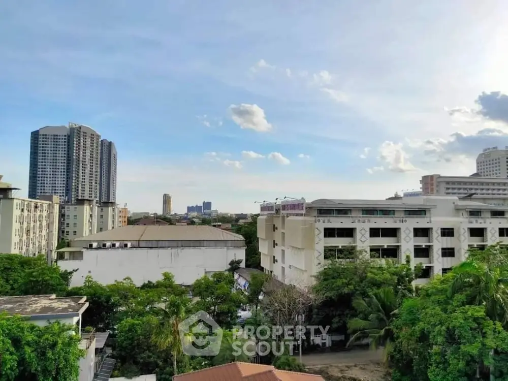 Stunning cityscape view with lush greenery and modern buildings under a clear blue sky.
