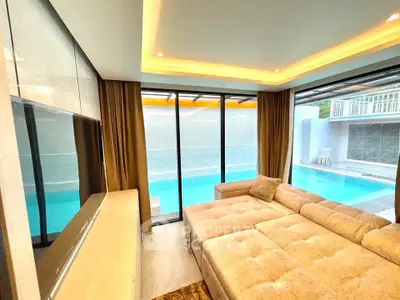 Luxurious living room with pool view and plush sectional sofa, perfect for relaxation.