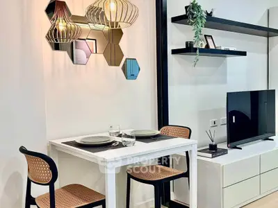 Modern dining area with stylish lighting and TV setup in a cozy apartment.