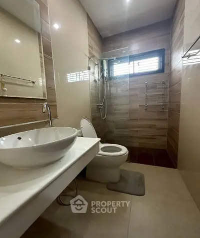 Modern bathroom with sleek fixtures and stylish tile design, featuring a spacious shower area.